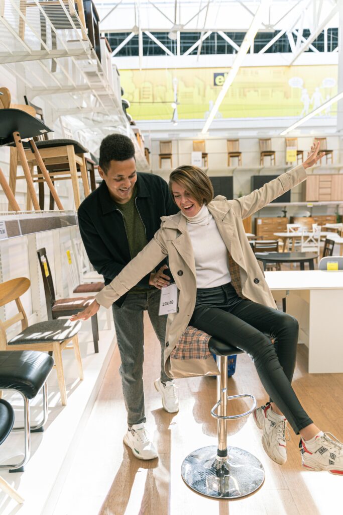 A cheerful couple enjoying their time shopping for furniture indoors.